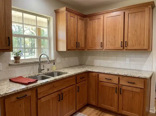 Illustration of stained wood kitchen cabinets with a granite countertop